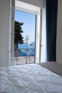 - une chambre avec un lit et une vue sur l'océan dans l'établissement Le Radici, à Castellammare di Stabia