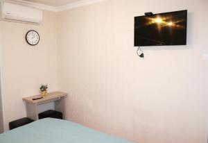 a room with a bed and a tv on the wall at Guest House Old Tiflis 5 in Tbilisi City
