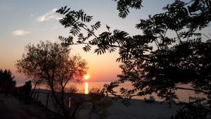 a sunset over the ocean with the sun in the distance at Pueblo Pokoje in Stegna