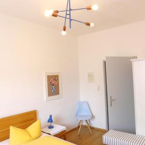 a bedroom with a bed and a blue chair at Pension Stoi budget guesthouse in Innsbruck