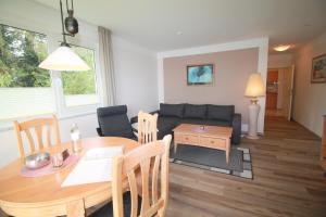 a living room with a table and a couch at Ferienwohnung Seeblick Plöner See in Ascheberg