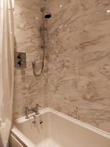 a bathroom with a shower and a bath tub at Buckieburn - self-catering - rural in Stirling