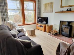 ein Wohnzimmer mit einem Sofa und einem Kamin in der Unterkunft Buckieburn - self-catering - rural in Stirling