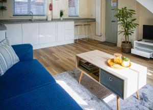 a living room with a blue couch and a table at Walking distance to hospital and town with free off-road parking in Bury Saint Edmunds