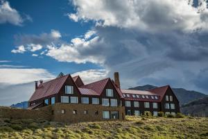 a house on a hill with mountains in the background at Los Cerros del Chaltén Boutique Hotel in El Chalten