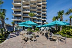 a patio with tables and umbrellas in front of a hotel at Nautilus Inn - Daytona Beach in Daytona Beach
