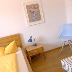 ein Schlafzimmer mit einem Bett und einer Lampe auf einem Tisch in der Unterkunft Pension Stoi budget guesthouse in Innsbruck