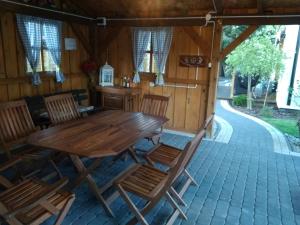 a wooden table and chairs on a patio at Apartament 6 osobowy in Kujan