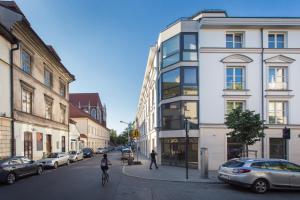 uma rua da cidade com edifícios e pessoas a andar de bicicleta em Silver Apartment Old Jewish Quarter em Cracóvia