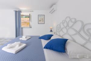 a bedroom with a large bed with blue and white pillows at B&B Mediterraneo in Procida
