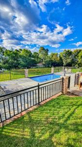 a fence around a swimming pool in a yard at Exquisite Pont de Val Riverside Escape Apartment in Parys