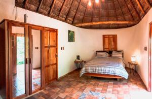 a bedroom with a bed and a wooden ceiling at Cenote San Ignacio in Chocholá