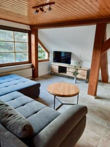 een woonkamer met een bank en een tafel bij Ein Bett im Kornfeld - Haus Morgensonne - mit Innenpool in Schönfeld