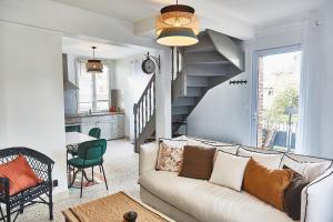 a living room with a couch and a staircase at Demeure de Manneville - SPA - 1Km des plages de Cabourg in Dives-sur-Mer