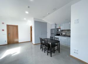 a kitchen and dining room with a table and chairs at Soldouro Train Suites in Aveiro