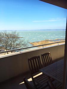 two chairs sitting on a balcony looking out at the ocean at Club 218 Wellness Luxus Apartman in Siófok