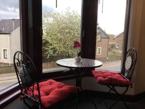 a table and two chairs in front of a window at Modern 1 Bedroom Apartment central Inverness city in Inverness