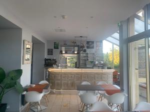 uma cozinha com um balcão, uma mesa e cadeiras em Hotel Le Ceinturon em Hyères