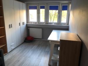 an empty room with a table and two windows at Apartament Zielone Bielany in Warsaw