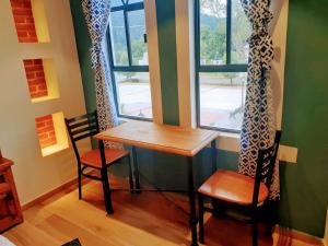 a table and two chairs in a room with a window at Hotel Bello Amanecer in Mineral del Chico