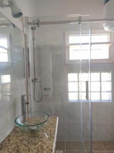 y baño con lavabo de cristal y ducha. en Playa Grande, en Piriápolis