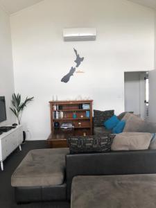a living room with a couch and a cat on the wall at Hills Vista Lodge in Matamata