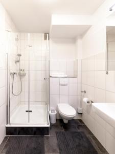 uma casa de banho com um chuveiro, um WC e um lavatório. em Stylish apartment - 3 Min walk to Wuppertal main train station - Close to the University - Kitchen - Netflix em Wuppertal
