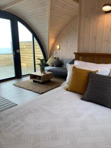 a bedroom with a large bed and a couch at Orkney Lux Lodges - Hamnavoe in Stromness