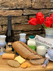 una mesa con pan de queso y botellas de vino y flores en Orkney Lux Lodges - Hamnavoe en Stromness