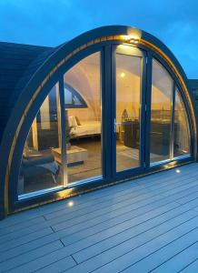 an arched window on a house with a patio at Orkney Lux Lodges - Hamnavoe in Stromness