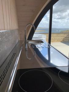 a kitchen counter with a sink and a window at Orkney Lux Lodges - Hamnavoe in Stromness +6 photos