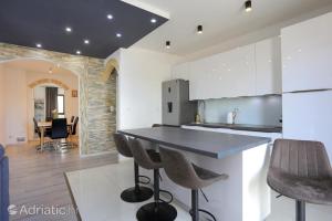 a kitchen with a counter and chairs in a room at Apartments Bagaric in Trogir