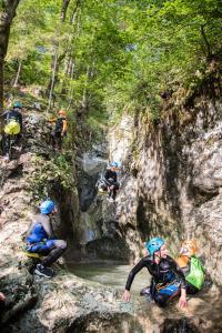 Un gruppo di persone che cavalcano lungo un fiume in una cascata di House Budkovič a Bohinj