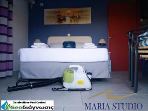 a bedroom with a bed with a vacuum next to it at Maria Studios in Poros Island in Poros