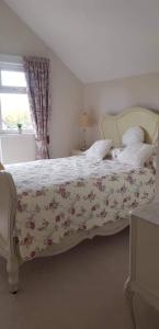 um quarto com uma cama com colcha floral em Lavender Cottage em Presteigne