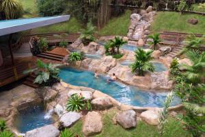 a pool of water surrounded by trees and shrubbery at Chachagua Rainforest Hotel & Hot Springs in Fortuna