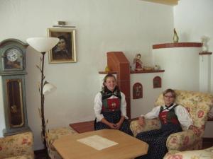 a man and a woman sitting in a living room at Hotel Humlerhof in Gries am Brenner