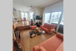 ein Wohnzimmer mit orangefarbenen Möbeln und einem großen Fenster in der Unterkunft WOLF'S PLANE Luxury Isolated Mountain House for Digital Nomads in Fojnica