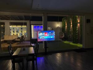 a living room with a television and a dining room at Luxury OVO Roof Villa in Taif