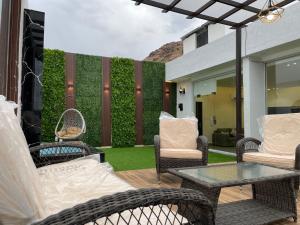 Luxury OVO Roof Villa في الطائف: فناء مع كراسي الخوص وطاولة