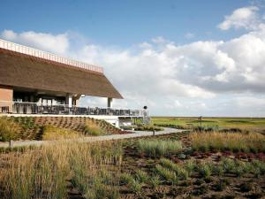 ein Gebäude mit einem Grasdach auf einem Feld in der Unterkunft 6 person holiday home on a holiday park in Rømø in Sønderby