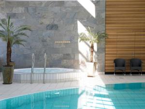 ein Swimmingpool mit zwei Stühlen neben einem Swimmingpool in der Unterkunft 6 person holiday home on a holiday park in Rømø in Sønderby