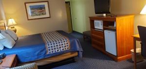 a hotel room with a bed and a television at VICTORIAN INN in Central City