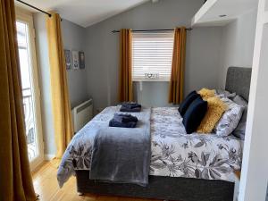 um quarto com uma cama com almofadas azuis em Detached one bedroom house near to castle and cathedral em Lincoln