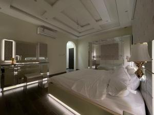 Luxury OVO Roof Villa في الطائف: غرفة نوم بسرير ومكتب ومصباح