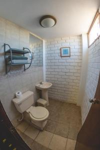 a bathroom with a toilet and a sink at Hotel El Mirador KITE-SURF, WIND-SURF AND SURF in Pacasmayo