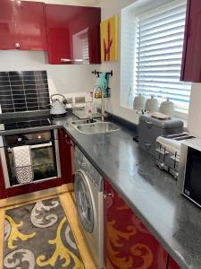 a kitchen with a sink and a washing machine at Detached one bedroom house near to castle and cathedral in Lincoln