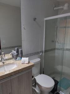 y baño con aseo, lavabo y ducha. en Winterville Flat 708, en Gravatá