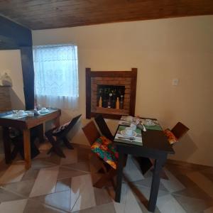 una sala da pranzo con 2 tavoli, sedie e camino di Luar de Minas suites a Lavras Novas