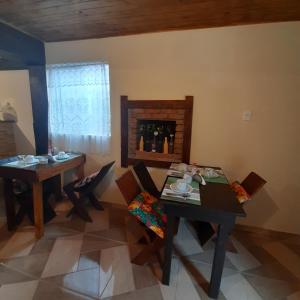 a dining room with two tables and chairs and a fireplace at Luar de Minas suites in Lavras Novas